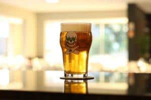 blonde ale beer in skull and cross bones beer glass on counter top