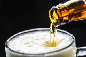 Home brew being poured from a bottle in a beer glass